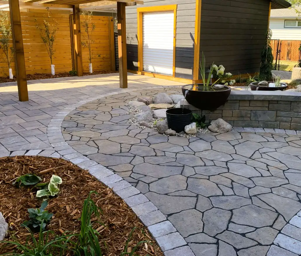 Natural stone patio with interlocking pavers and garden border
