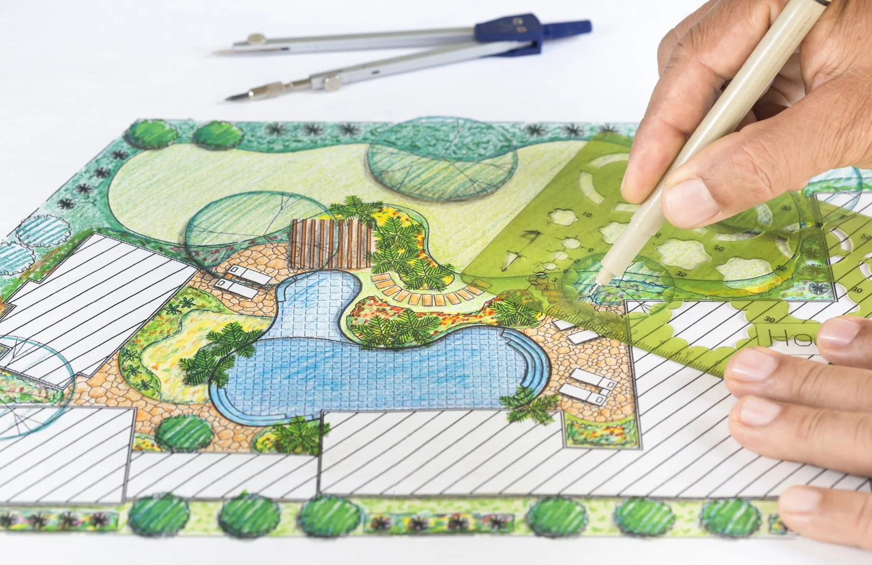 Detailed landscape design blueprint laid over a garden site with measuring tools